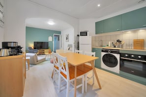 A compact living space with a dining area, kitchenette, and a small seating area. - La Maison Petite Pause - plage à 150 m (Bray-Dunes)