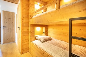 A wooden cabin interior with bunk beds, a door, and a window. - L’écrin 206 - Quartier des Bergers - Proximité immédiate ESF (Huez)