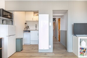 A compact kitchen with a microwave, refrigerator, and dishwasher. A television is mounted on the wall to the right. - Les Envols de Chamrousse - Proche Télécabines (Chamrousse)