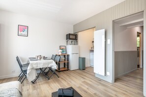 A compact kitchen with a microwave, refrigerator, and a dining area with a table and chairs. - Les Envols de Chamrousse - Proche Télécabines (Chamrousse)