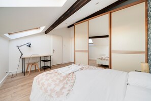 A bedroom with a skylight, a desk, a chair, a bed, and a wardrobe. - Le Vivaldi - Proche de la Gare (Nancy)