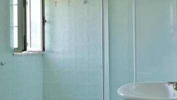 Ein Badezimmer mit Duschkabine, Waschbecken und Toilette.