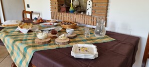 Une table à manger dressée avec différents plats, bols et une assiette décorative, ce qui indique que le repas est prêt à être servi.