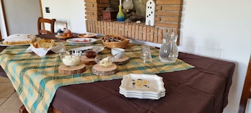Mesa de comedor dispuesta con distintos platos, fuentes y un plato decorativo, indicando una preparación para comer.
