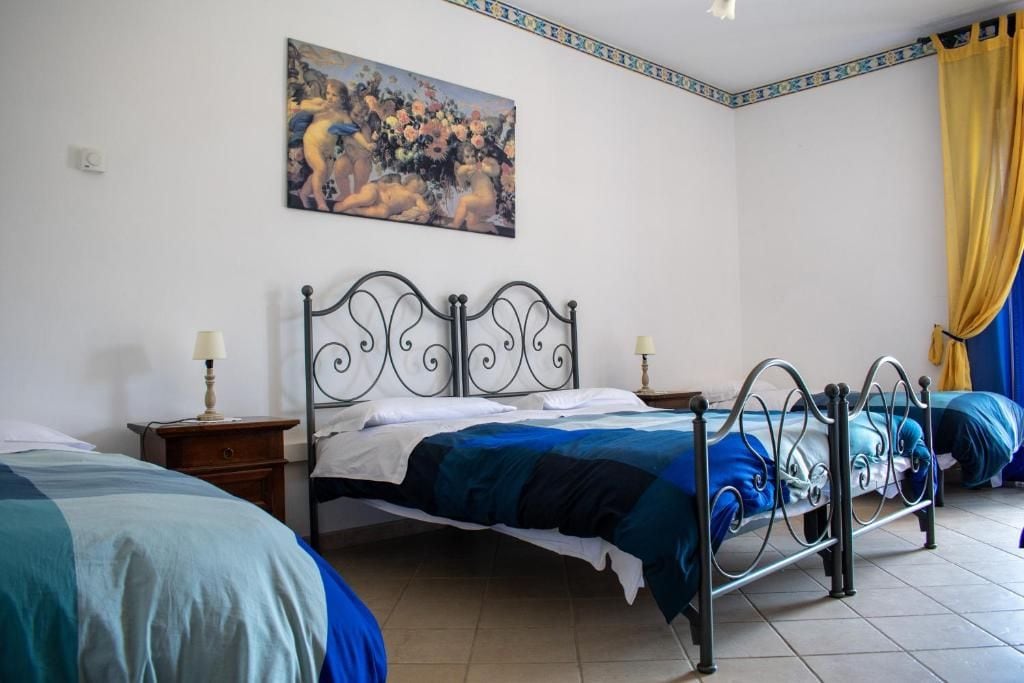 Een slaapkamer met twee bedden, een schilderij aan de muur en een gordijn.