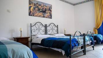 Een slaapkamer met twee bedden, een schilderij aan de muur en een gordijn.