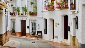 A narrow street with white buildings, balconies with plants, and a clear sky. - Modern 2-bed, 2-bathroom by the pool,  Las Fuentes de Nerja (Nerja)