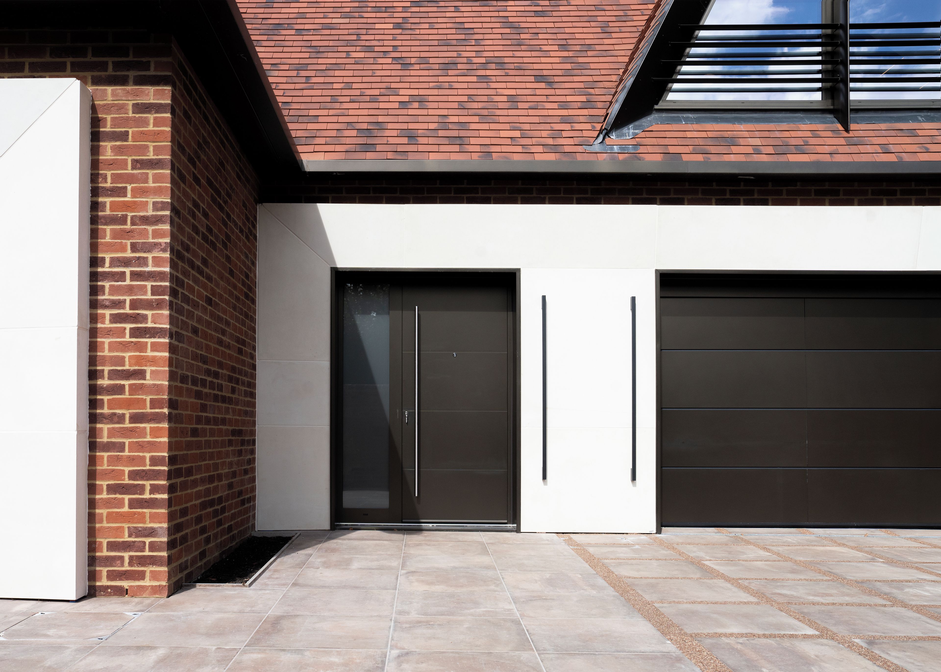 Een modern gebouw met een bakstenen gevel, een plat dak en twee garagepoorten.