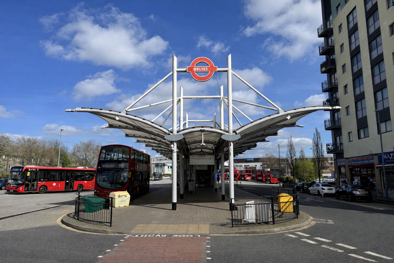 Une gare routière dotée d’un abri remarquable et surplombée d’un ciel d’un bleu éclatant.