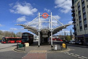 A bus station with a distinctive shelter and a clear blue sky. - 3 Bed House with garden Free Parking near Tottenham Stadium (London)
