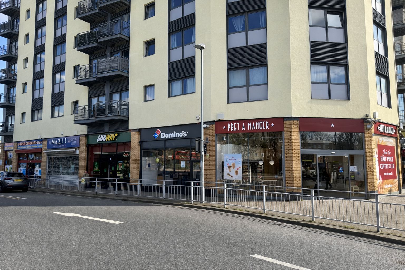 A multi-story building with various storefronts including a Subway, Domino's, and Pret A Manger.