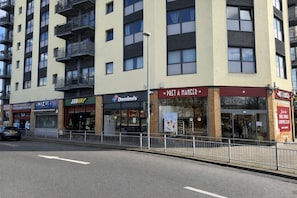Un edificio de varios pisos con diversas tiendas, incluyendo Subway, Domino's y Pret A Manger.
