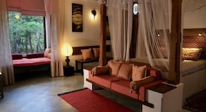 Una habitación con una cama, un sofá, una mesita de noche y una lámpara.
