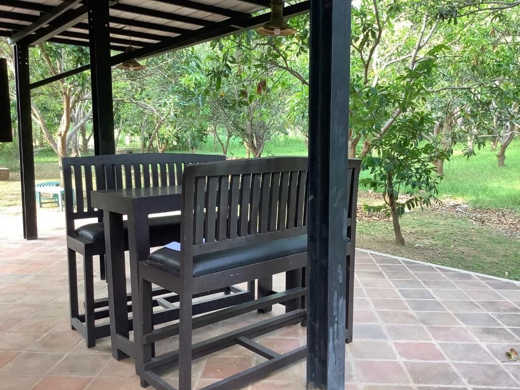 Een overdekt terras met banken en een pergola.