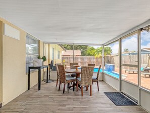 A covered patio with a dining table and chairs, a fan, and a potted plant. - Deerfield Coastal House - Cozy Stay (Deerfield Beach)