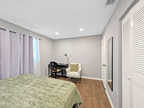 A bedroom with a bed, a desk, a chair, and a wardrobe. - Deerfield Coastal House - Cozy Stay (Deerfield Beach)