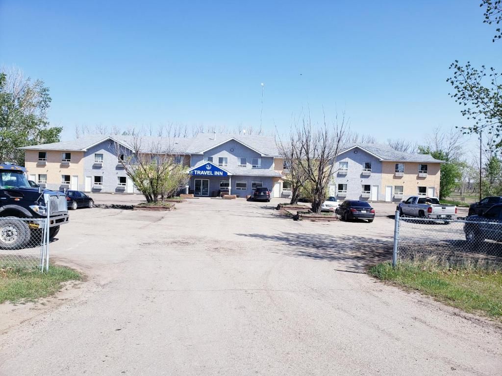 A Travel Inn hotel with a parking lot and multiple vehicles.