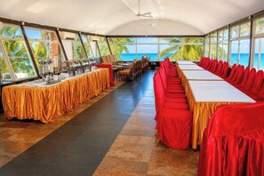 A restaurant with a view of the ocean, featuring long tables and chairs, and a ceiling fan. - Lido beachfront resort  (Mombasa)