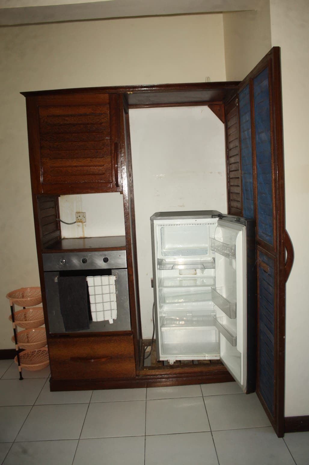 Une cuisine compacte dotée d’un four encastré et d’un réfrigérateur.