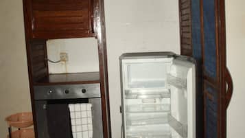 Une cuisine compacte dotée d’un four encastré et d’un réfrigérateur.