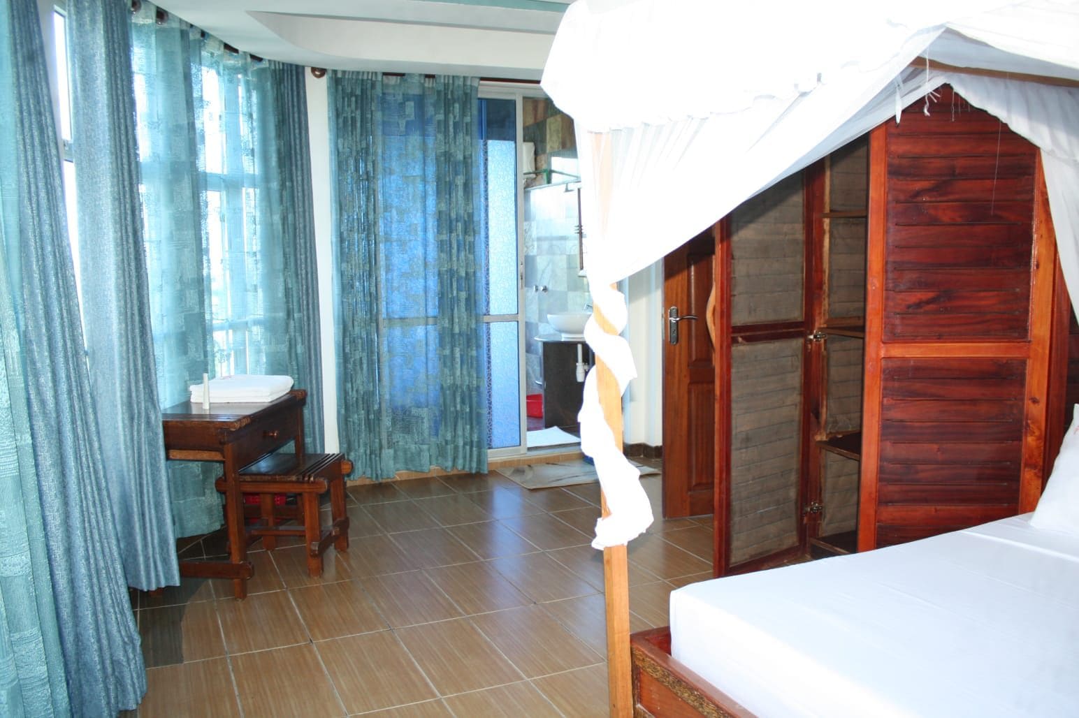 Une chambre avec un lit, un bureau, une chaise et une armoire.