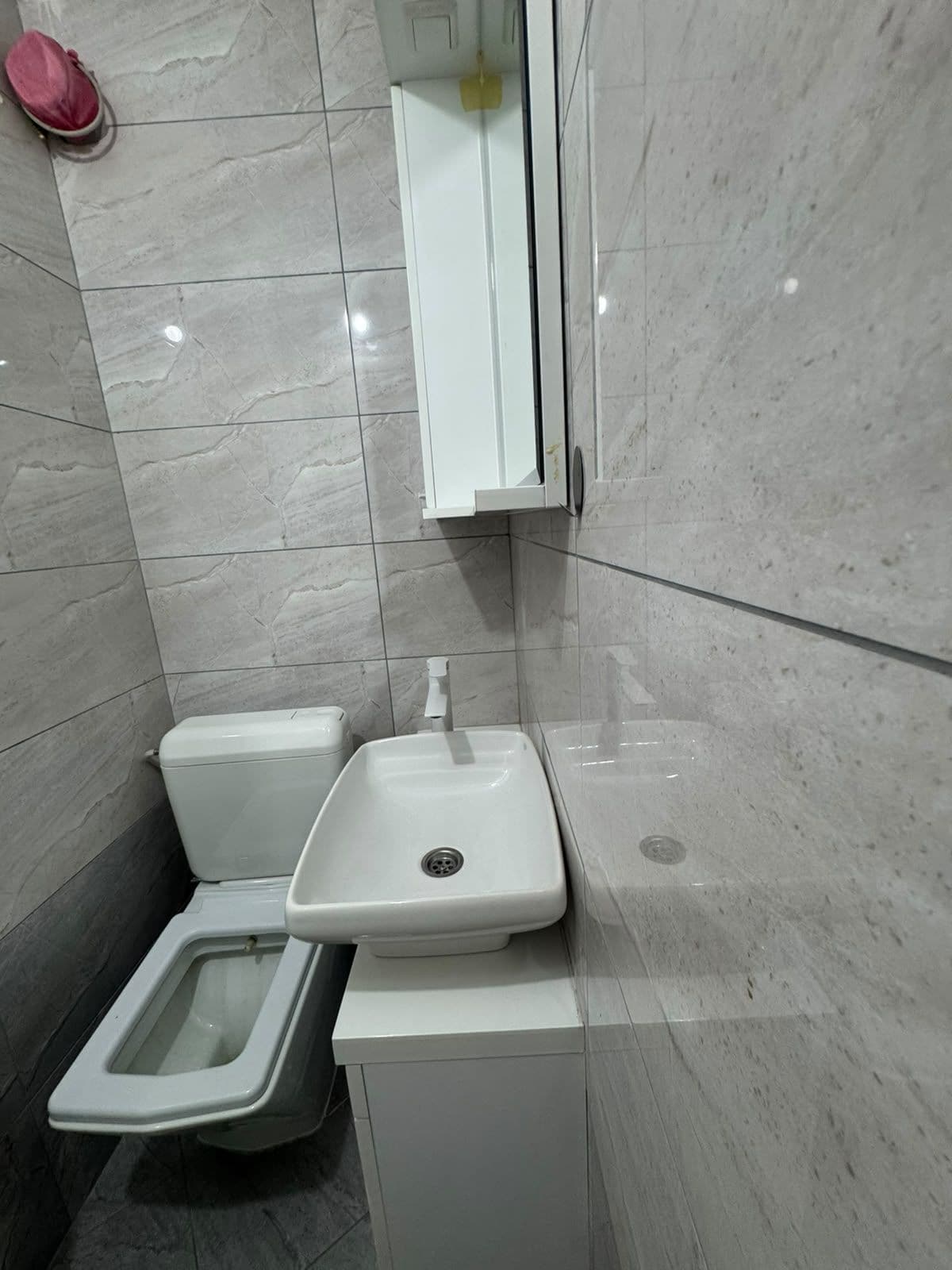 Un baño con inodoro, bidé y lavamanos.