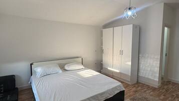 Une chambre à coucher avec un lit, une armoire et un luminaire suspendu.