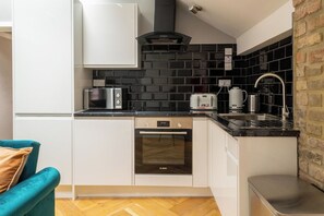 Eine kleine Küche mit einem Bosch-Backofen, einem Toaster und einem Spülbecken.