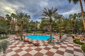 A pool area with checkered flooring, lounge chairs, and palm trees. - Luxury Las Vegas Strip!  1BR Private Residences Condo ~ 24/7 Pool 1-08 (Las Vegas)