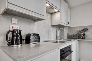 Eine moderne Küche mit Backofen, Wasserkocher, Toaster und Spüle.