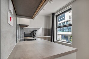 Eine moderne Küche mit einem großen Fenster, einer integrierten Spüle und einer Arbeitsplatte.