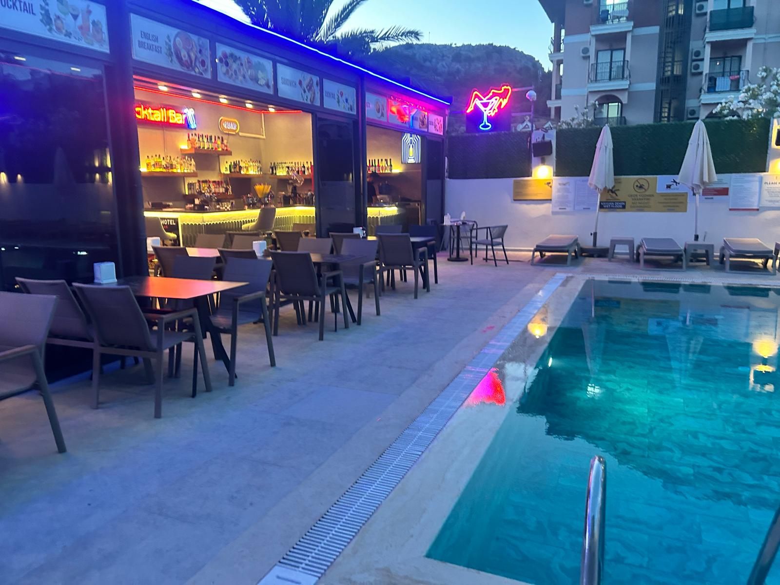 Zona junto a la piscina con bar y asientos.