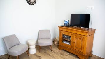 Una habitación con un armario de madera, un televisor y dos sillas.