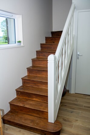 A wooden staircase with white balusters leading to a door. - Holiday Home 'La Parenthèse Cauchoise' with Sea View, Comfort and Tranquility (Malleville-les-Grès)