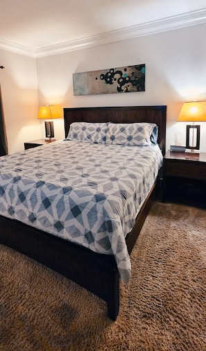A bedroom with a bed, two bedside tables, a wall-mounted artwork, and a textured carpet. - Luxury Las Vegas Strip!  1BR Private Residences Condo ~ 24/7 Pool 2-09 (Las Vegas)