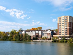 A multi-story hotel with a mix of brick and modern architecture, situated by a body of water.