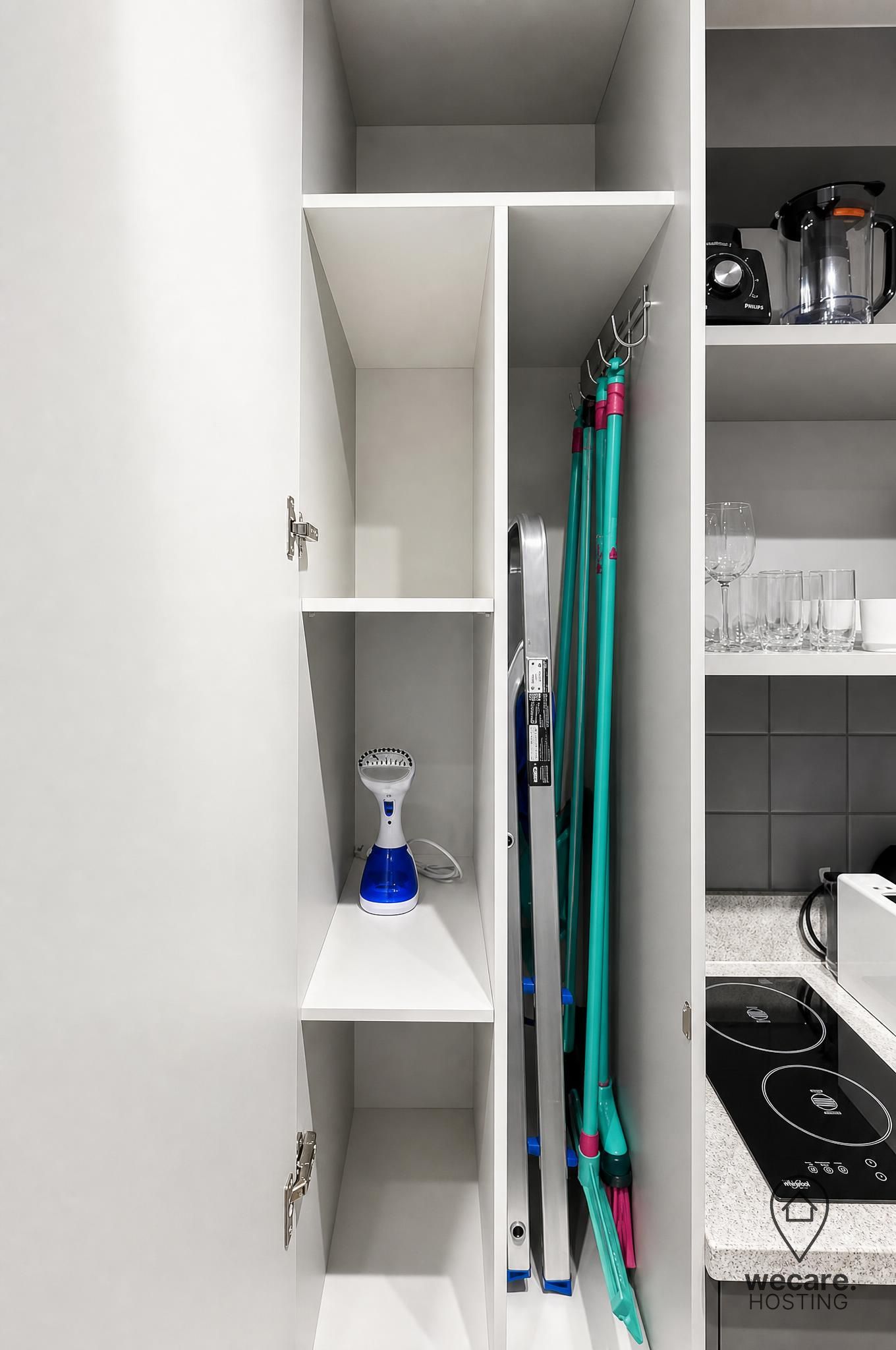 Una cocina con estufa integrada, cafetera y un vaso de agua sobre la encimera.