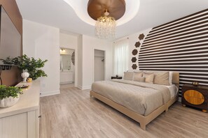 Een moderne slaapkamer met een groot bed, een nachtkastje, een spiegel en een wand met decoratieve panelen.