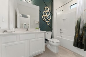 Un bany modern amb un lavabo blanc, un vàter, una banyera i una dutxa.