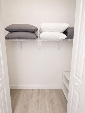 A closet with shelves holding pillows and a white door. - Heated Saltwater Pool | Near Beach | Pets Welcome! (Rotonda West)