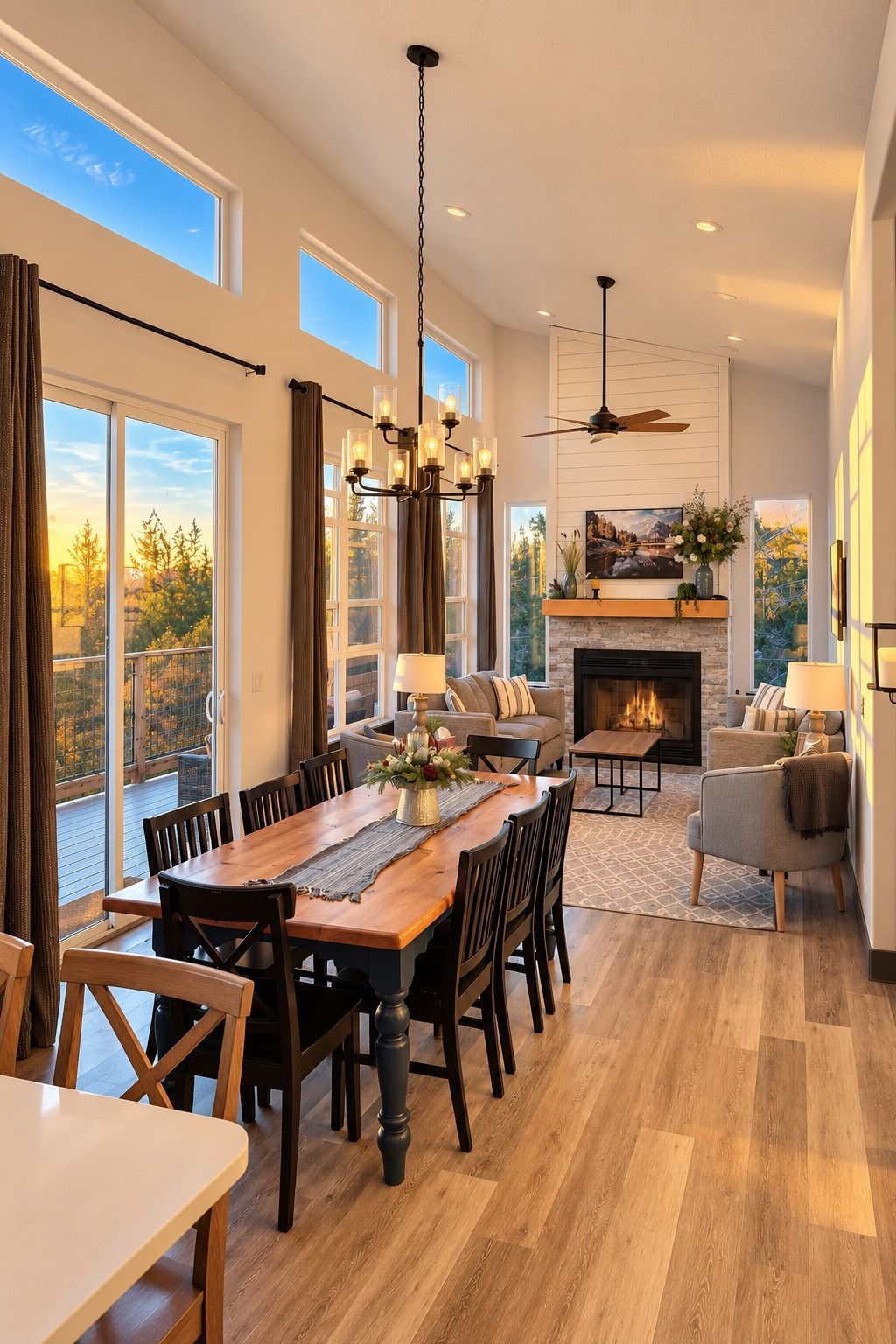 A spacious living room with a fireplace, a dining area with a wooden table and chairs, and a balcony with large windows.