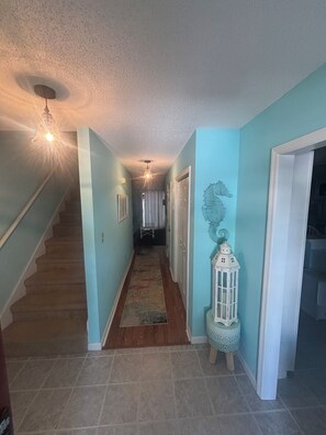 A hallway with a wooden staircase, a patterned rug, and a white lantern. - Sea Horse Beach House 2BR 3BA Sleep7,with Pool Near Cherry Grove4Mile From Beach (Little River)