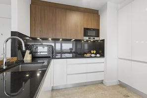 A modern kitchen with a built-in oven, microwave, and stainless steel sink. - Elegant 1BR in Prime Colón Madrid (Madrid)