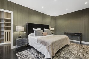 Ein Schlafzimmer mit Bett, Nachttischen, einem Schrank und einem Schreibtisch.