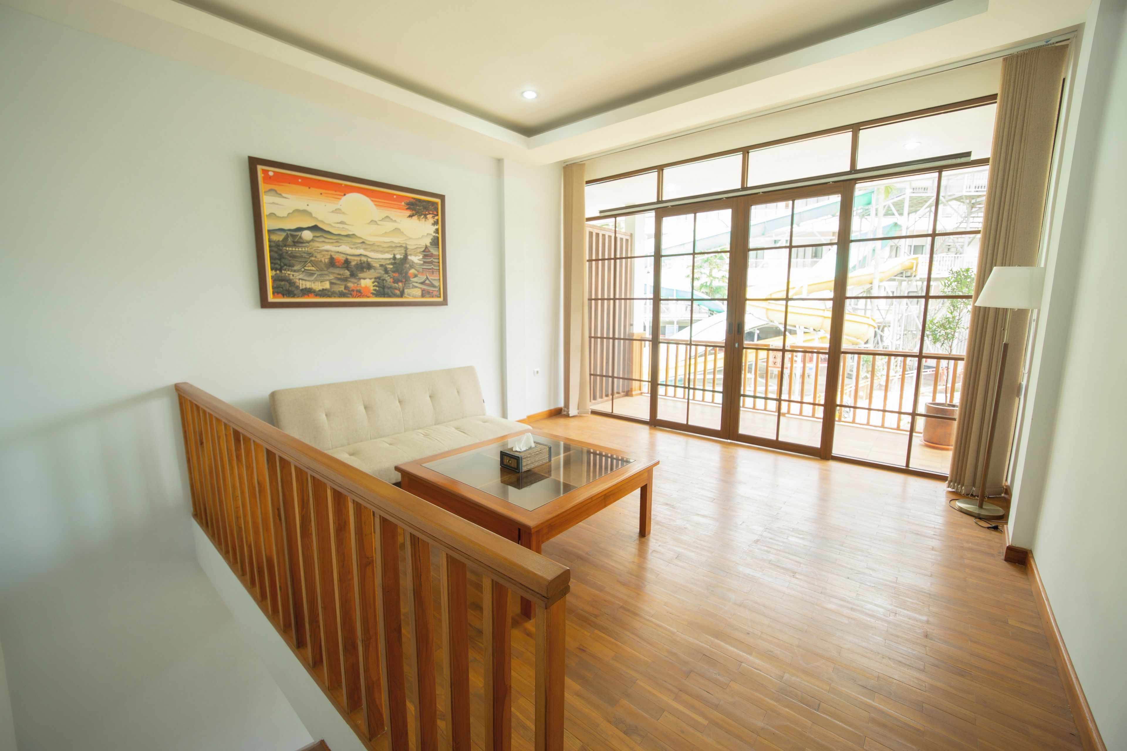 A living room with a sofa, a coffee table, and a painting on the wall.