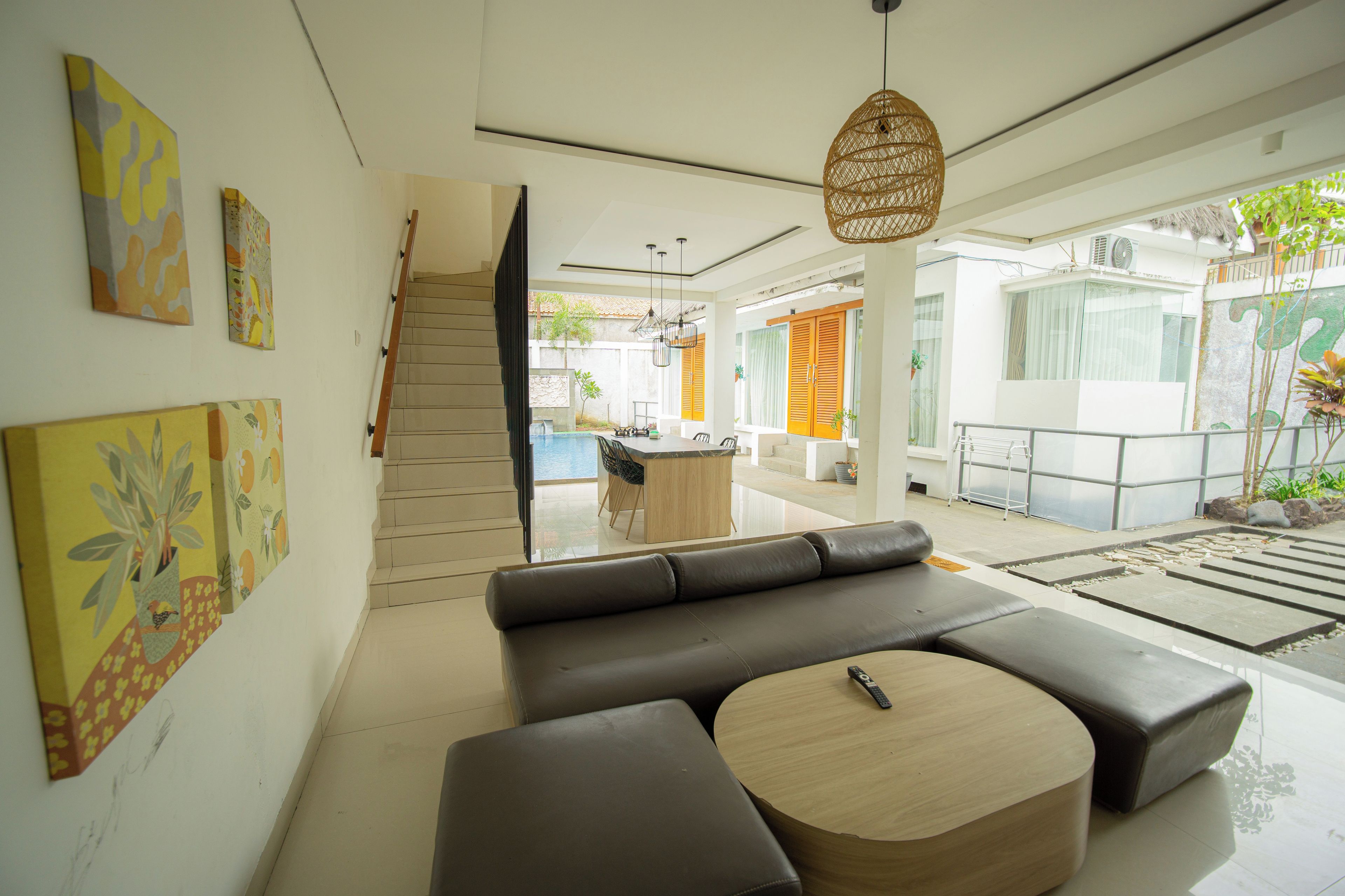 A modern living room with a sofa, a round coffee table, and artwork on the walls.