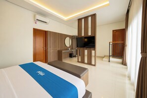 Una habitación de hotel con cama, televisión, escritorio y baño.