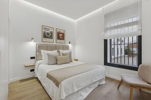 Ein Schlafzimmer mit einem Bett, einem Sessel und einem Fenster.