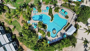Ein Resort mit mehreren Schwimmbecken, Palmen und Liegebereichen.