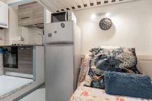 Una cocina compacta con refrigerador, microondas y estufa.